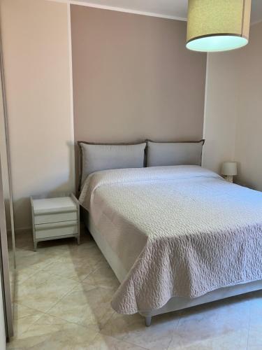 1 dormitorio con 1 cama con edredón blanco en La casa dell'Asparago, en Messina