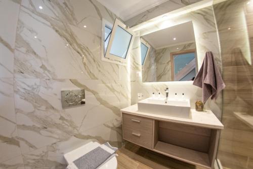 a bathroom with a sink and a mirror at Jasmine Hotel & Apartments in Agios Stefanos