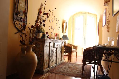 a living room with a vase with flowers in it at Hotel Residence Le Chiavi Di San Francesco in Trapani