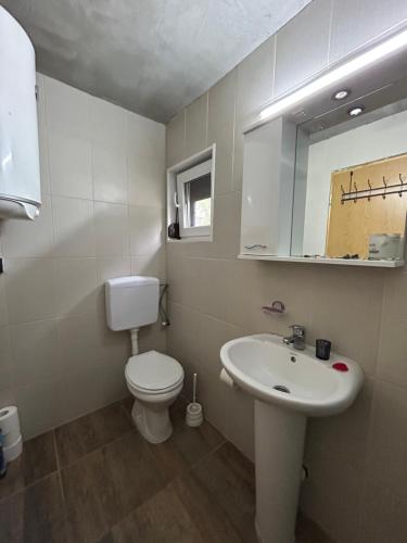a bathroom with a white toilet and a sink at Speakeasy Lux 3 - 4 in Ulcinj