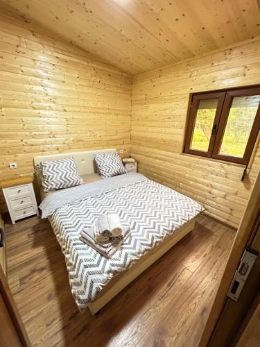 um quarto com uma cama num chalé de madeira em Speakeasy Lux 3 - 4 em Ulcinj