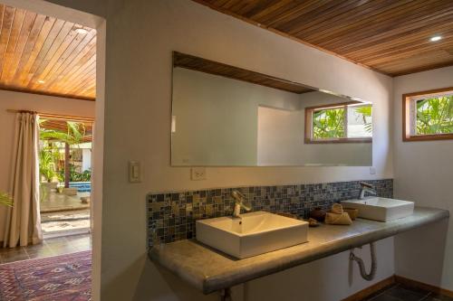 La salle de bains est pourvue de 2 lavabos et d'un miroir. dans l'établissement Dream Surf House Avellana, à Playa Avellana