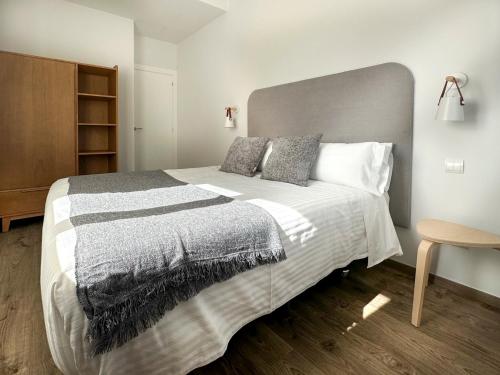 a bedroom with a large bed with a gray and white blanket at Le Petit Boutique Hotel in Santander