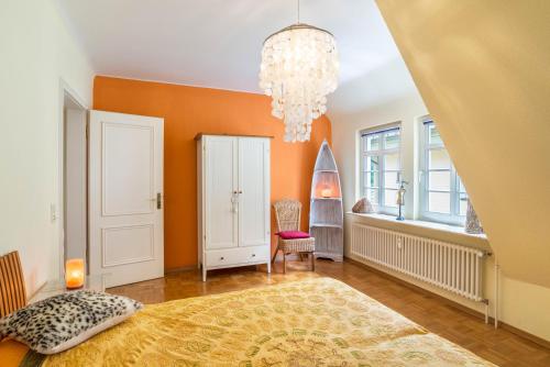 a bedroom with orange walls and a chandelier at Ferienwohnung Saline in Bad Wildbad