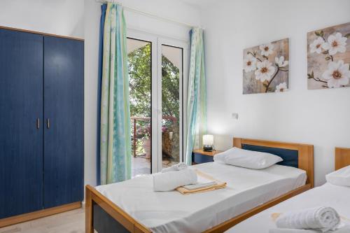 a bedroom with two beds and a window at Miranda Resort in Nikiana