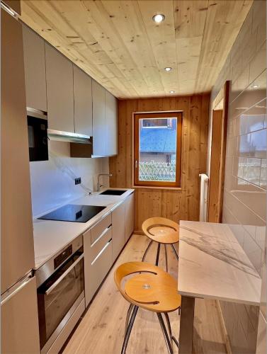 a kitchen with white cabinets and a table and chairs at Résidences Delavay La Cordée in Les Gets