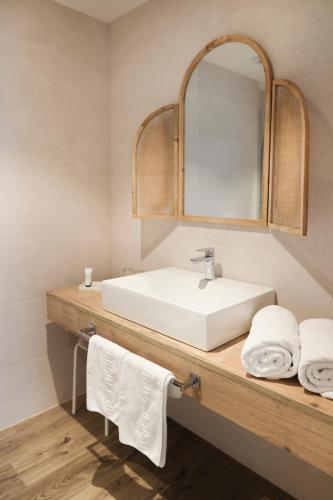 a bathroom with a sink and a mirror and towels at Le Petit Boutique Hotel in Santander