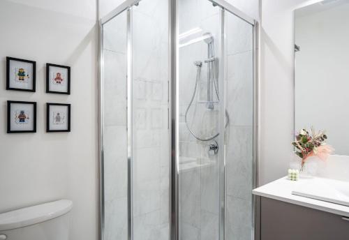 Baño blanco con cabina de ducha de cristal en The Ski Shanty by Revelstoke Vacations, en Revelstoke