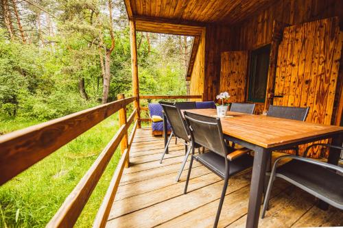 a wooden deck with a table and chairs on a cabin at Cozy Nature Retreat with Patio Fireplace Garden 