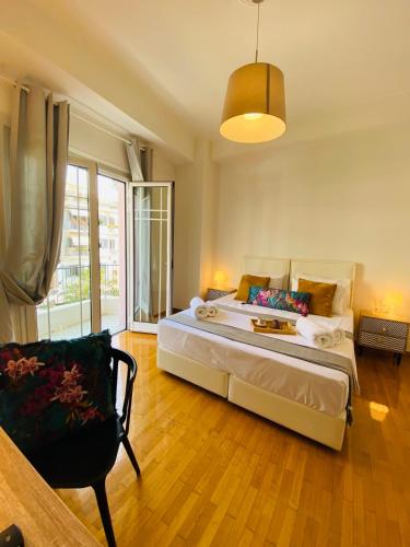 a bedroom with a large bed and a chair at 2 BD Apt in Koukaki 8’ away from Acropolis in Athens