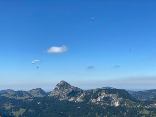 a cloud flying over a mountain range with trees at Mountain Moments Tannheim - Familie Weber in Tannheim