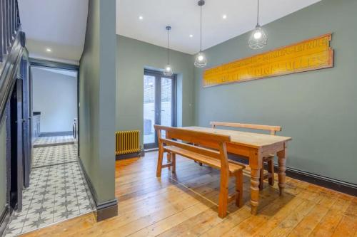 Inviting 4BD with Private Patio - Bethnal Green في لندن: غرفة طعام مع طاولة خشبية ومقعد