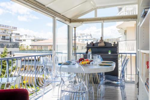 d'un balcon avec une table et des chaises blanches. dans l'établissement Penthouse Duplex with Rooftop Terrace, à Cannes