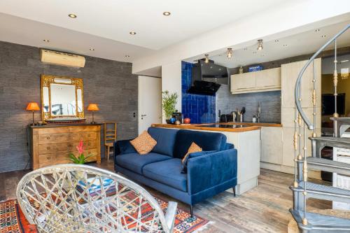 un salon avec un canapé bleu et une cuisine dans l'établissement Penthouse Duplex with Rooftop Terrace, à Cannes