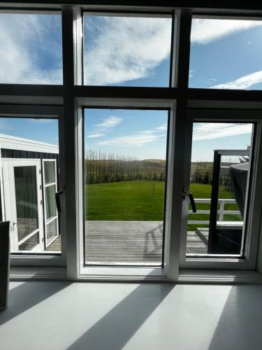a room with three windows and a view of a field at Jóhönnu Hús in Hella