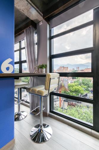 an office with a bar with a view of the city at Factory Lofts Hotel in Medellín