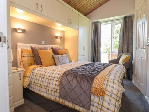 a bedroom with a large bed and a window at Doormouse Lodge in Carnforth