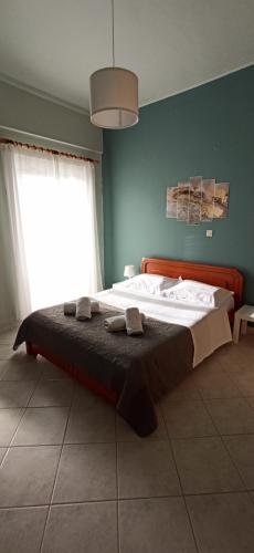 - un grand lit dans une chambre dotée d'un mur bleu dans l'établissement marianthi's apartment, à Plataria