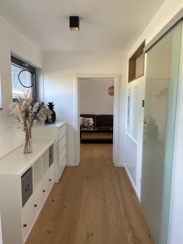 a hallway with white cabinets and a vase of flowers at Mit gutem Gefühl ferienwohnen in Ballingshausen