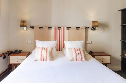 a bedroom with a large white bed with two pillows at Boutique Hôtel Txoko in Saint-Jean-de-Luz