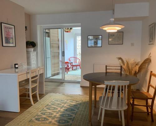 uma cozinha e sala de jantar com mesa e cadeiras em Comfy 3BD Home with Patio in Peaceful Ilminster em Ilminster