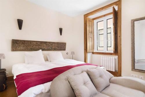 - une chambre avec un grand lit et un canapé dans l'établissement Classy 2BR in Principe Real w/ Heating, à Lisbonne