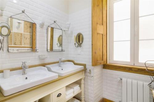 a white bathroom with two sinks and a window at Classy 2BR in Principe Real w/ Heating in Lisbon