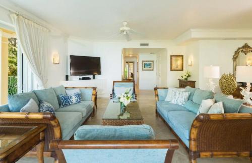 a living room with blue couches and a tv at Villa Renaissance in Grace Bay