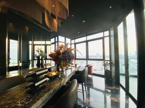 a large room with a long table with chairs and windows at Edge Central Pattaya Vip Condo in Pattaya