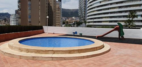 duży okrągły basen ze zjeżdżalnią w mieście w obiekcie Playa de Oro con Parking w mieście Calpe