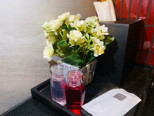 a table with a vase of flowers and a drink at Edge Central Pattaya Vip Condo in Pattaya Central