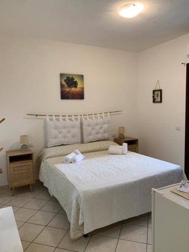 a bedroom with a large bed with two towels on it at Affittacamere La Petra Longa in San Teodoro