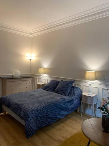 - une chambre avec un lit, deux tables et deux lampes dans l'établissement Apppartement des sacres de reims, à Reims