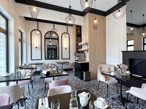 restauracja ze stołami i krzesłami oraz kominkiem w obiekcie Kurkowa Apartments w Szczecinie