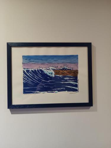 a framed painting of a wave on a wall at Boutique Hôtel Txoko in Saint-Jean-de-Luz