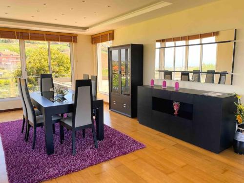 una sala da pranzo con tavolo e tappeto viola di Brazão Guest House a Santana