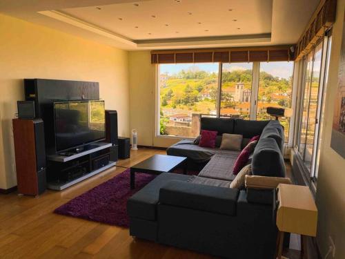 uma sala de estar com um sofá e uma televisão de ecrã plano em Brazão Guest House em Santana
