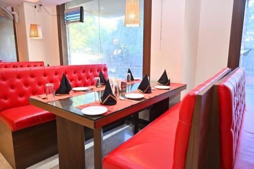 a dining room with a table and red chairs at Hotel Silver Land New Digha with Rooftop Pool in Digha