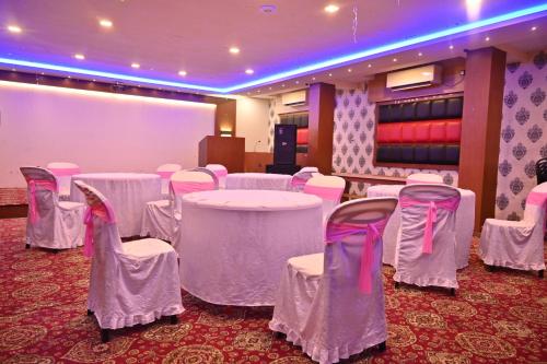 a room with white tables and chairs in a room at Hotel Silver Land New Digha with Rooftop Pool in Digha