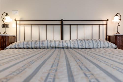 a bedroom with a bed with two lamps on it at Locanda Poggioleone in Castiglione del Lago