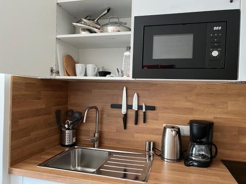 a kitchen with a sink and a microwave at Aparthotel Hochfeld in Schönau am Königssee