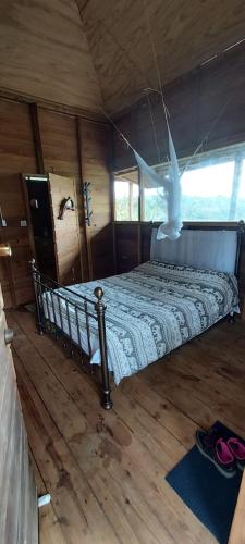 ein Schlafzimmer mit einem Bett in einer Holzhütte in der Unterkunft Bon Mange Organic Farm in Vieux Fort