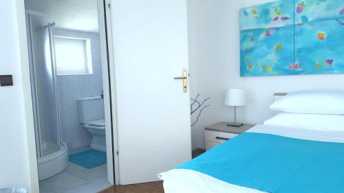 1 dormitorio con cama azul y baño en Rooms Josipa, en Rovinj