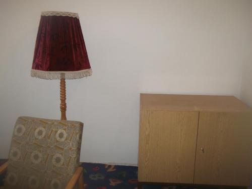 una lámpara en una habitación junto a un armario de madera en Restaurace s ubytováním, en Křižany