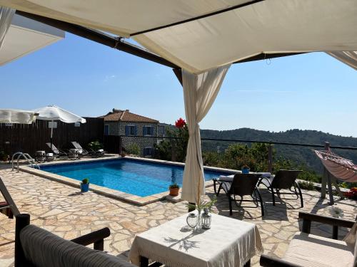 a patio with a pool and a table and chairs at Alseides Villas in Chort&aacute;ta