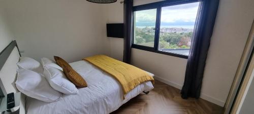 アジャクシオにあるPalazzu B reservation 3 nuits minimumの大きな窓のあるベッドのある寝室