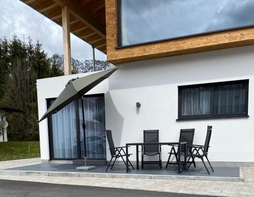 a patio with a table and chairs in front of a building at Mountain Moments Tannheim - Familie Weber in Tannheim