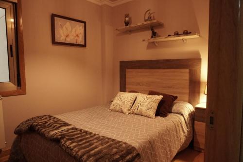 a bedroom with a bed with two pillows on it at Piso Alerín in Silleda
