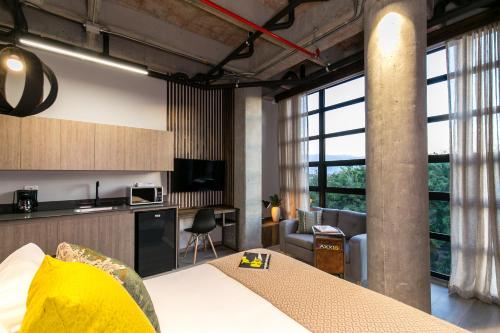 a room with a bed and a kitchen and a living room at Factory Lofts Hotel in Medellín