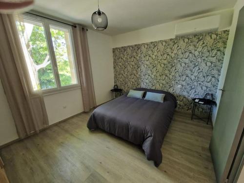 a bedroom with a large bed and a window at Bienvenue chez José et Hélène maison de village in Montfrin